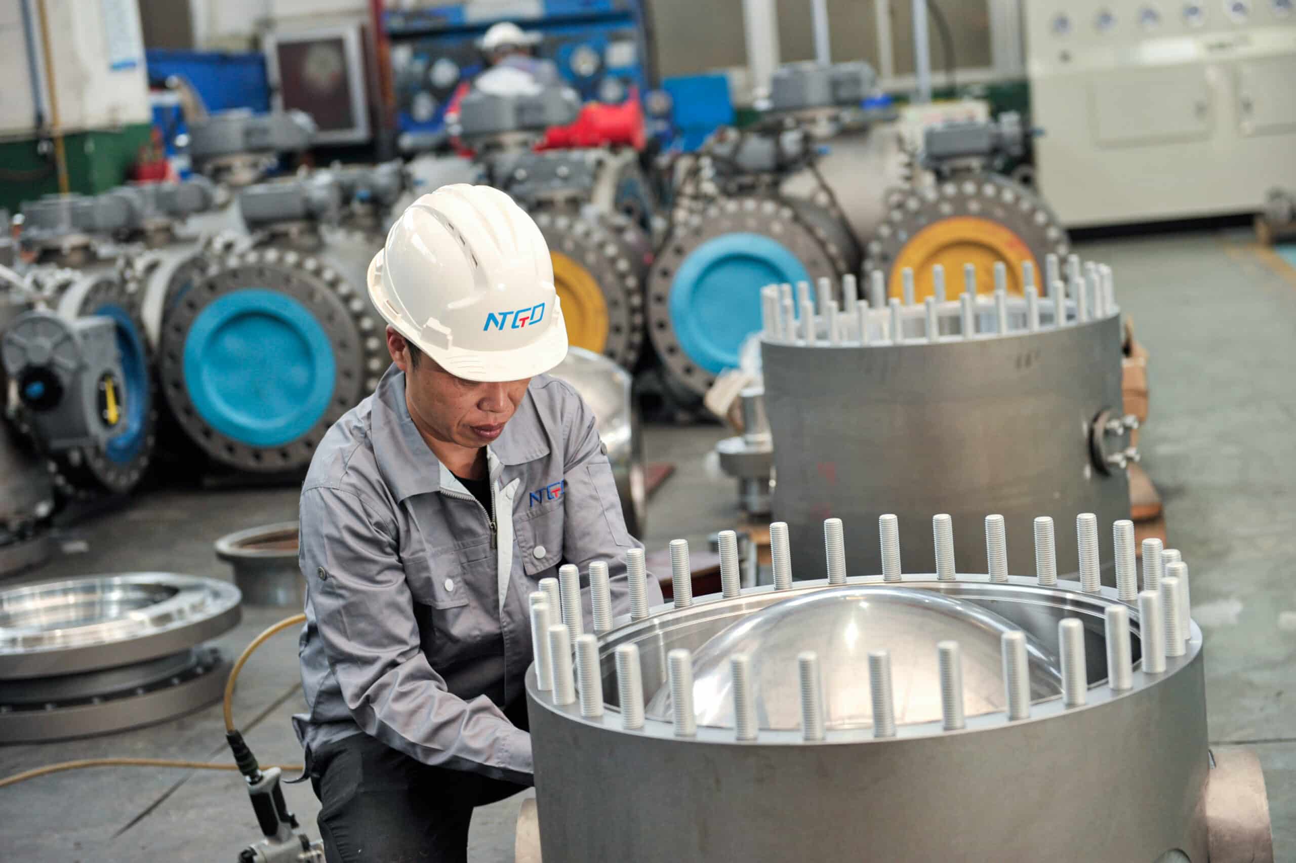 NTGD technician assembling a large industrial ball valve in workshop