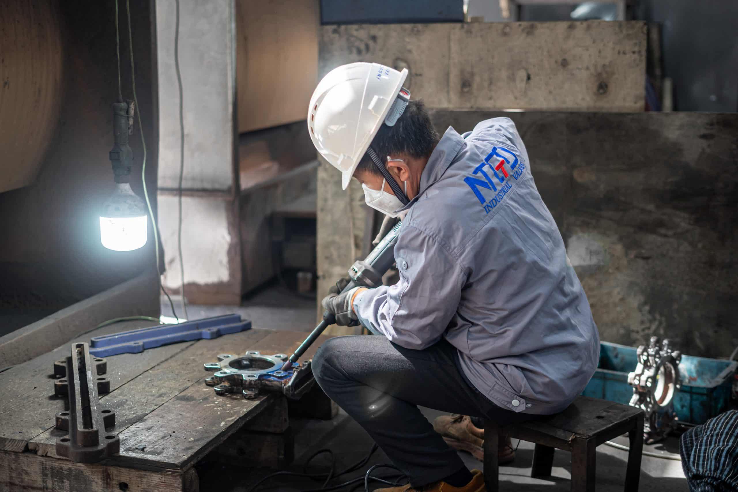 Manual de taller sobre la fabricación de válvulas industriales que muestra a un técnico montando componentes de válvulas en un entorno fabril dentro de la cadena de suministro de válvulas en Oriente Medio