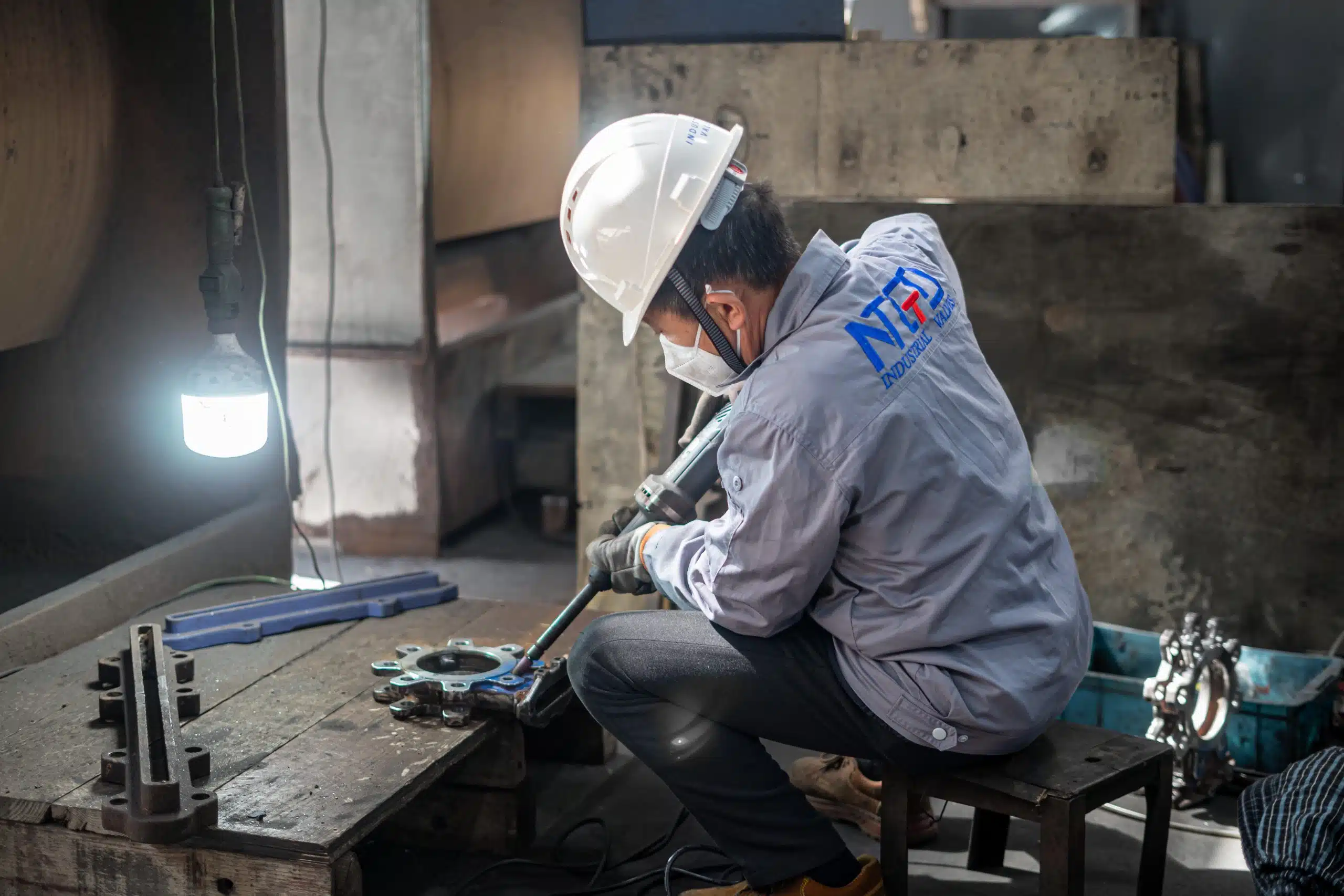 Industrial valve manufacturing workshop manual processing showing technician assembling valve components in factory environment in the Middle East valve supply chain