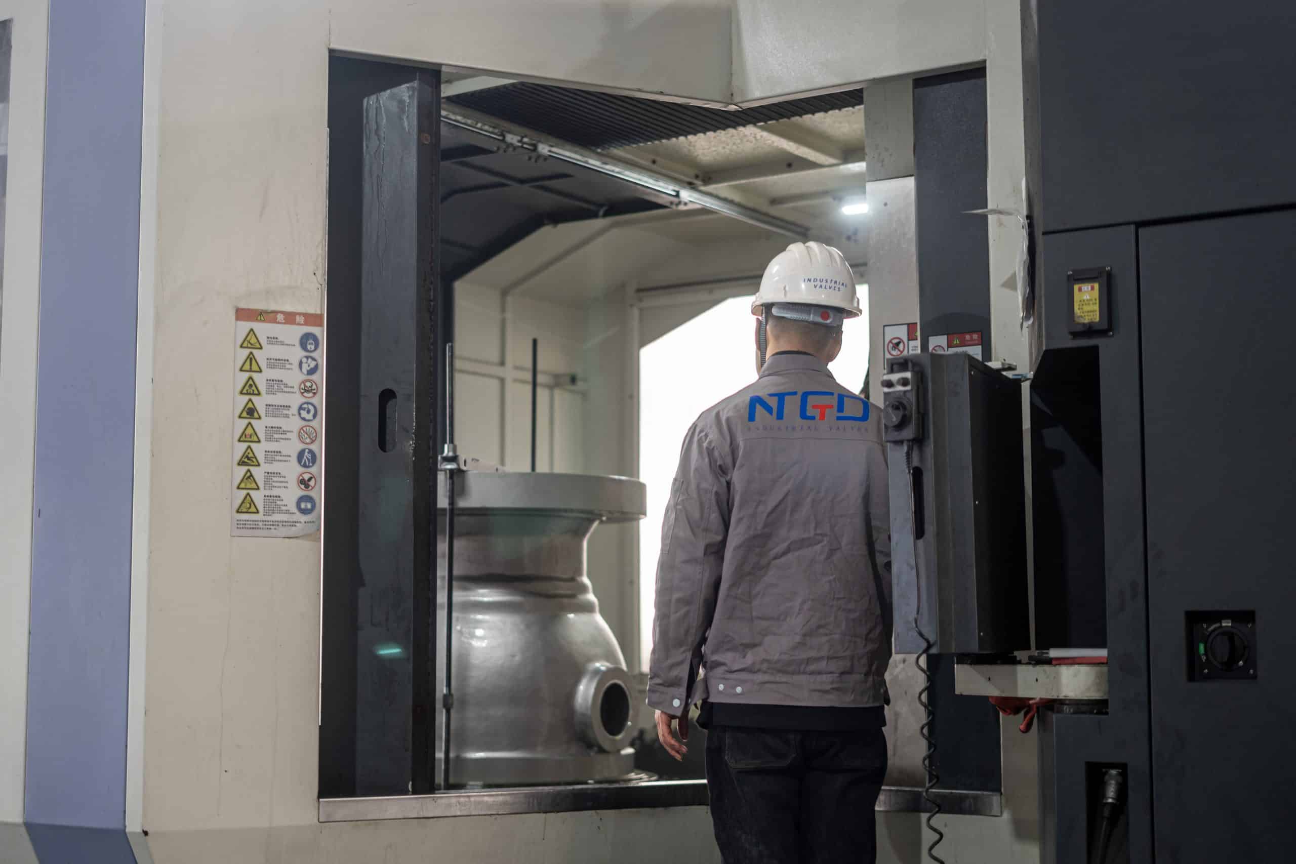 Large ball valve body being checked in a machining cell during production