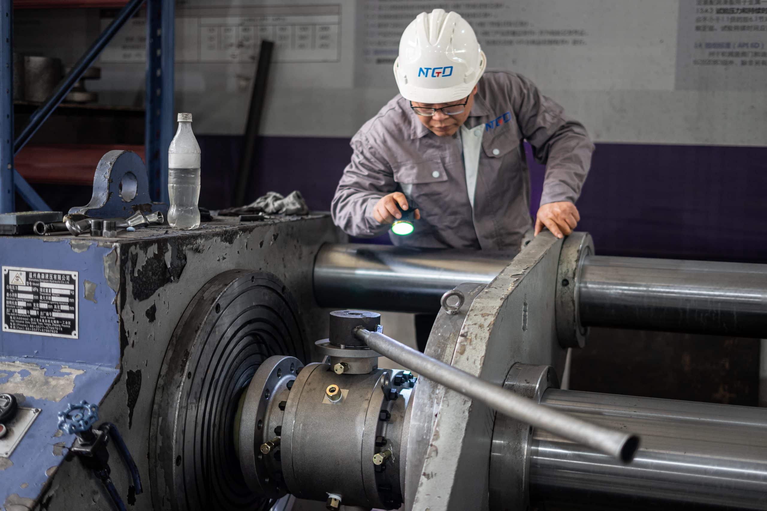 Technician inspecting a machined valve component during a workshop quality check