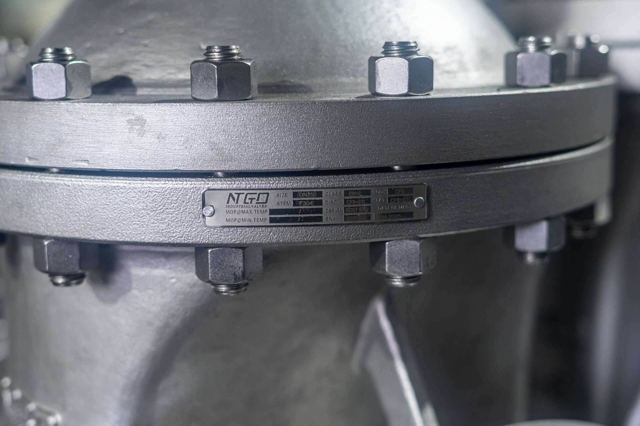 Close-up photo of a gate valve nameplate and serial marking on the valve body