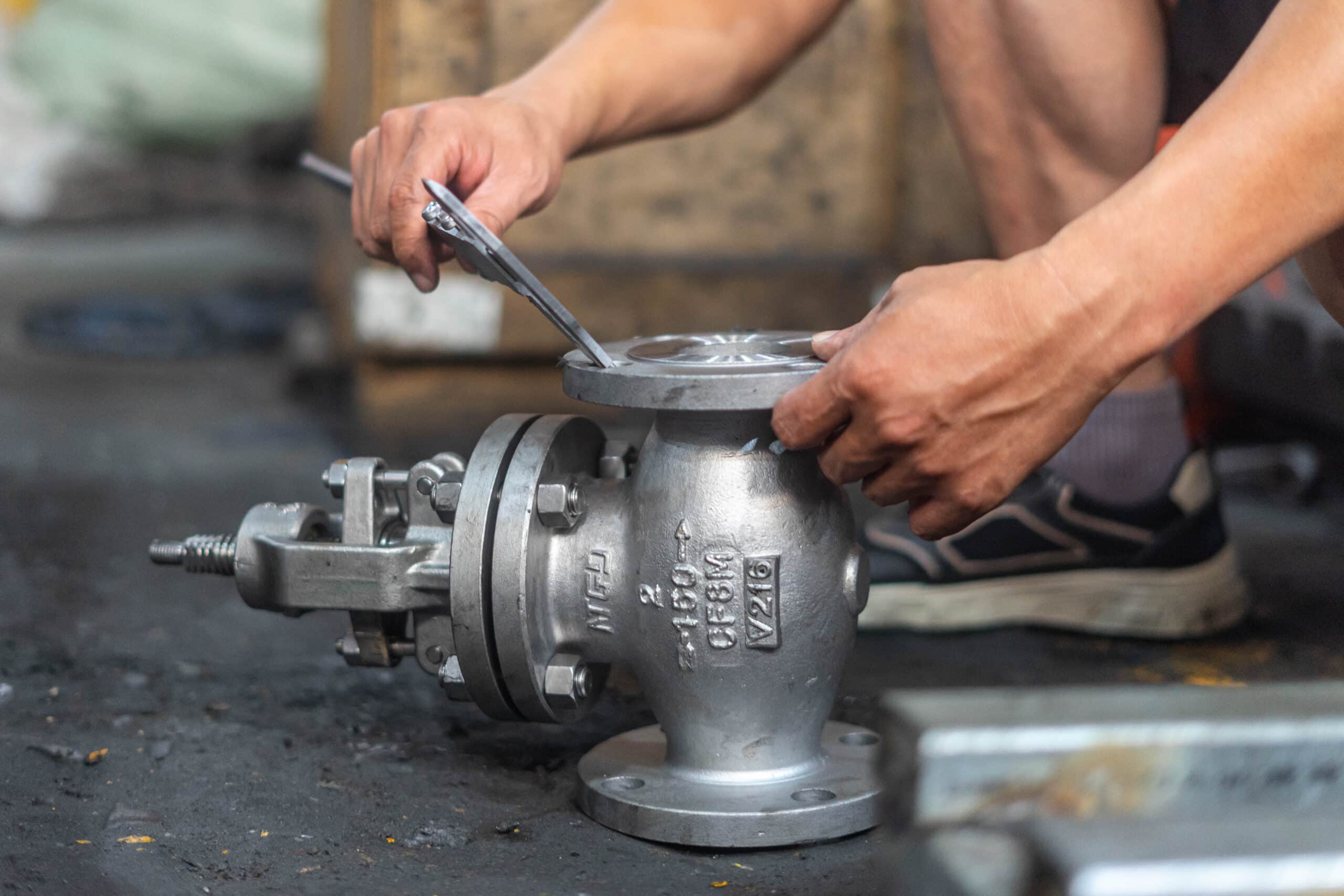 Workshop inspection photo showing measurement of a small flanged globe valve component before quotation.