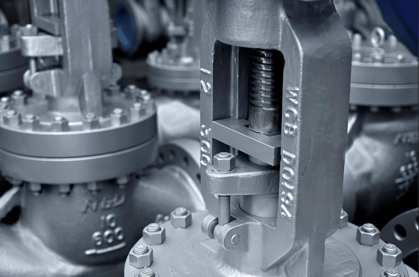 Close-up of real globe valve stem and yoke assembly showing the linear motion transfer area