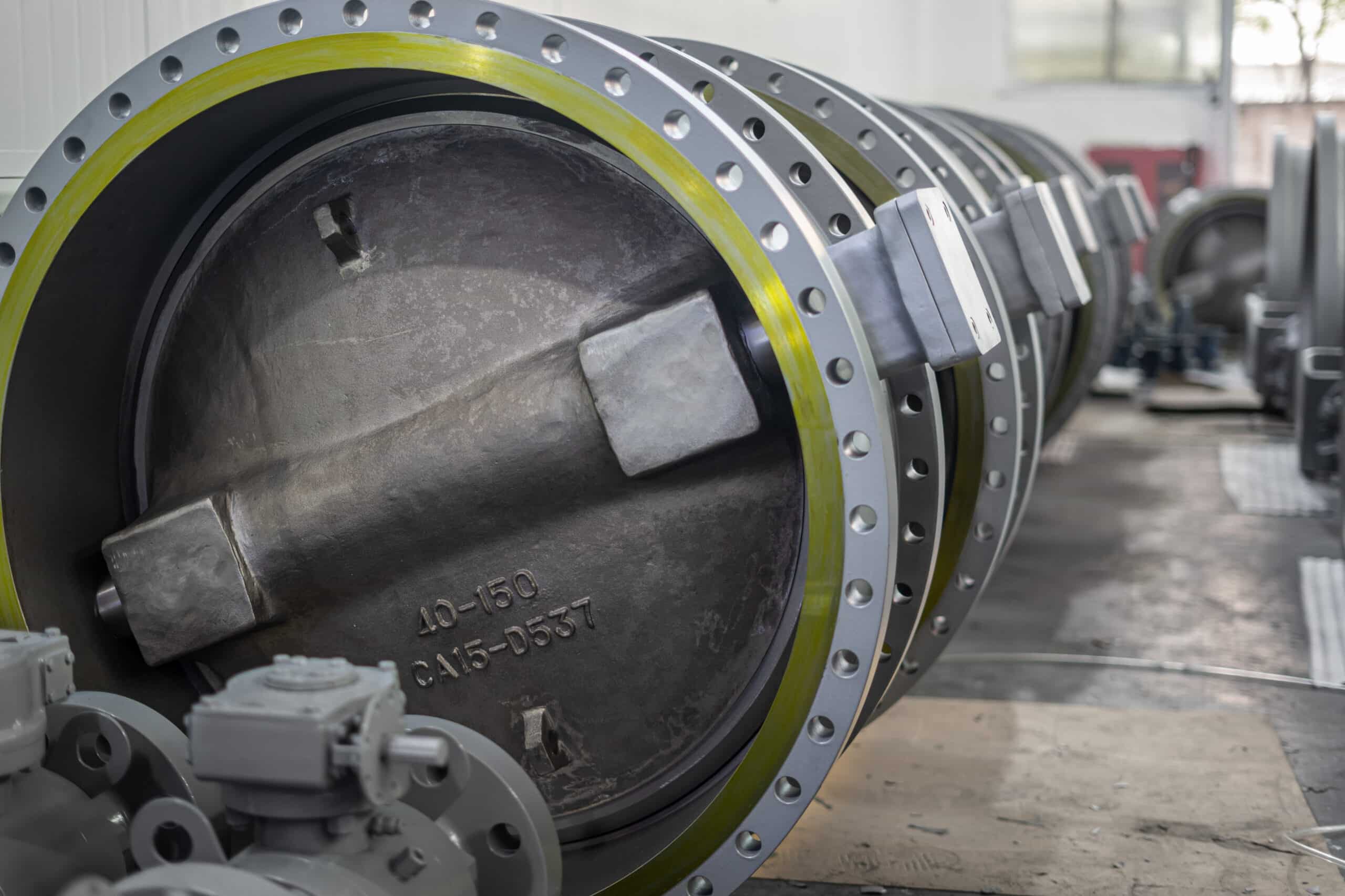 Row of large industrial butterfly valves in a factory workshop