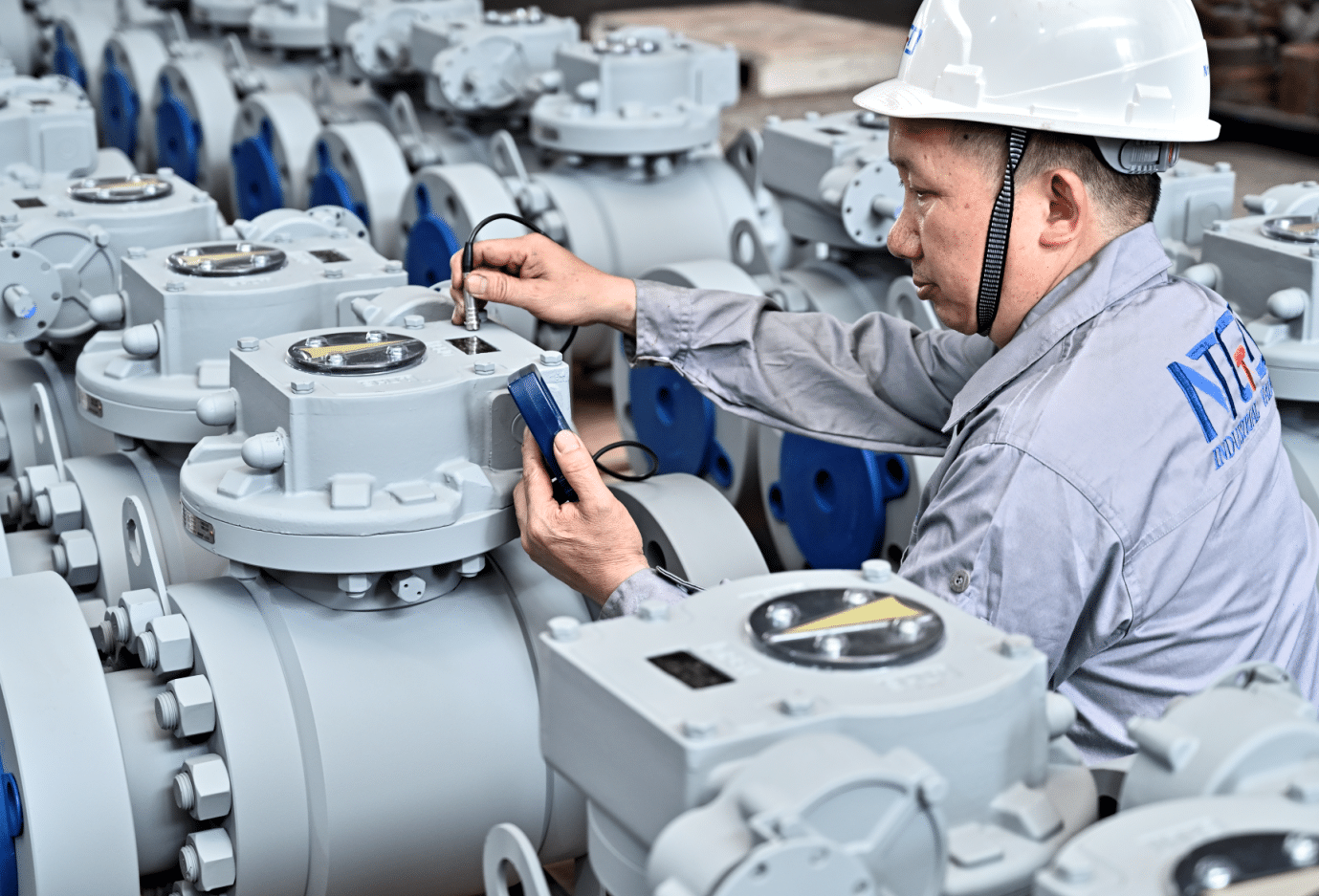NTGD technician inspecting industrial ball valves in the factory