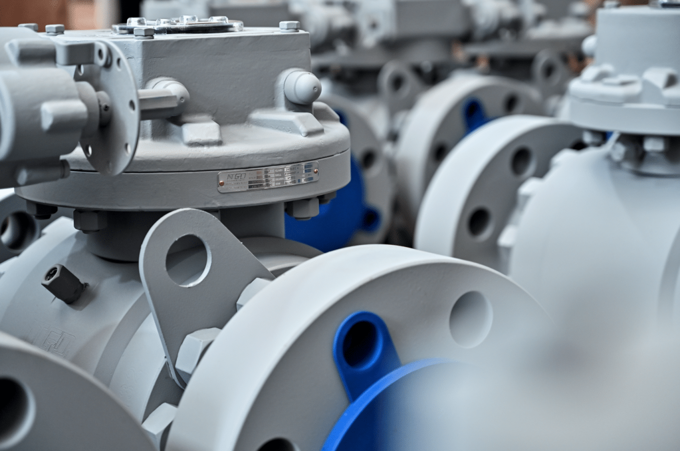 Close-up of industrial ball valve nameplate and flanged body in workshop