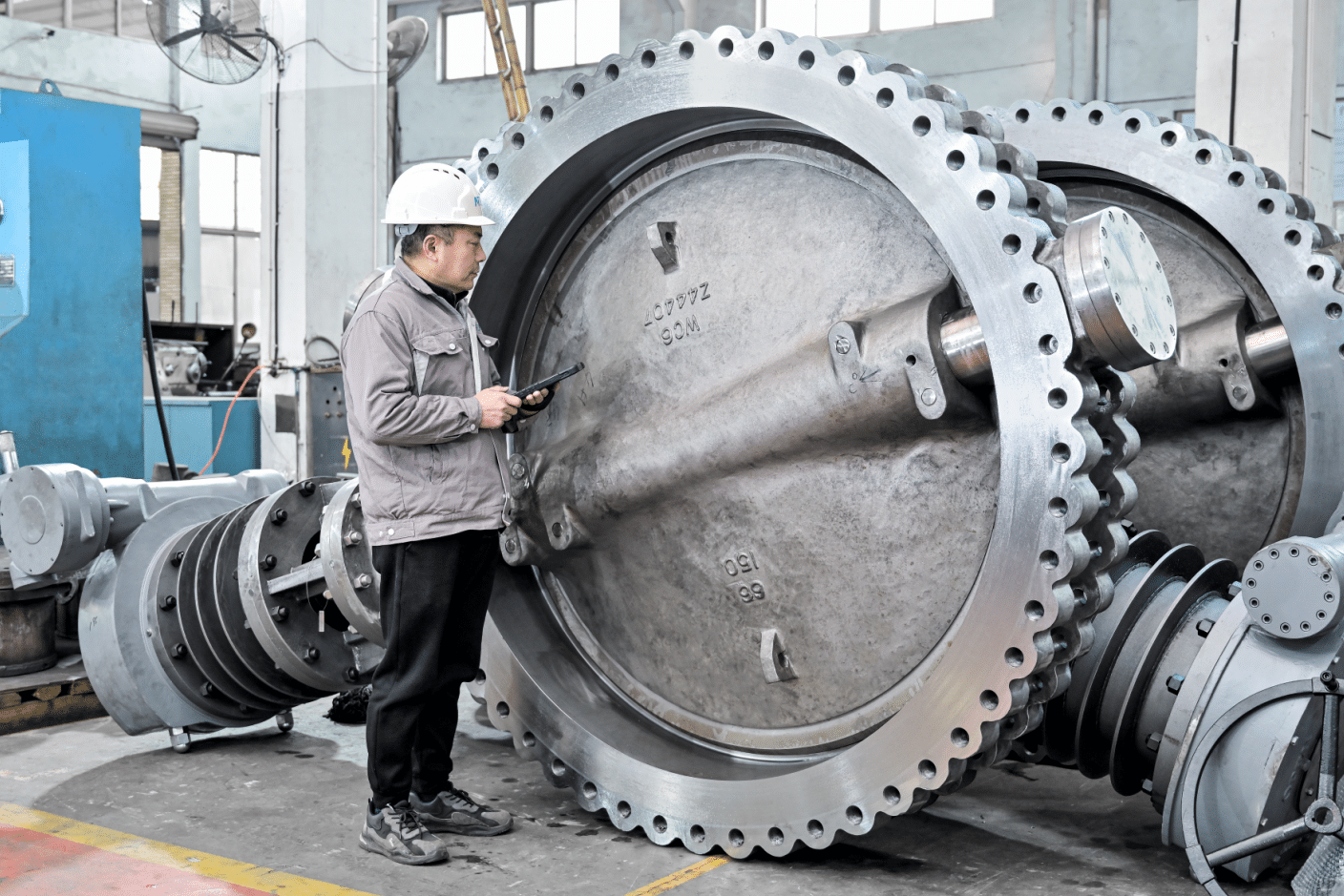 Worker inspecting a 66 inch triple offset butterfly valve in the factory