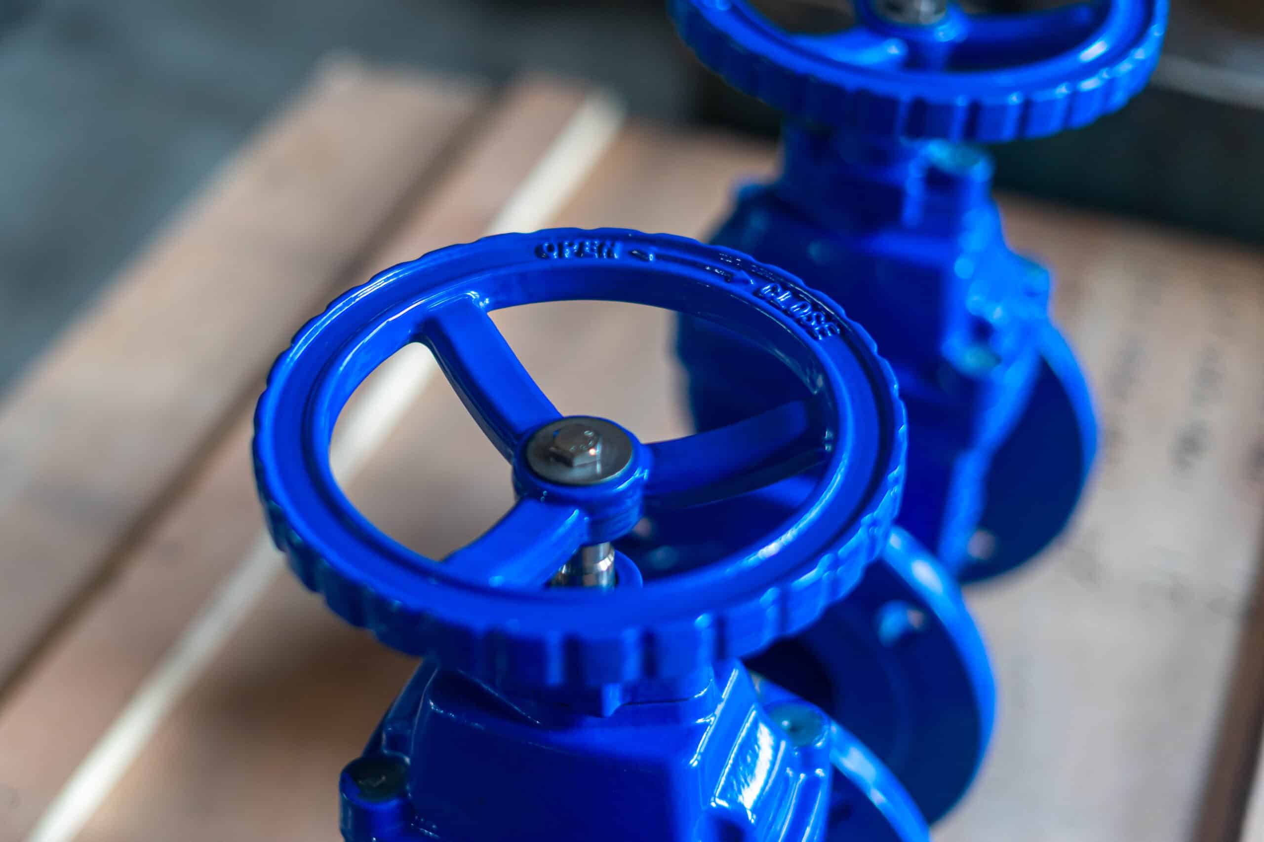 Primer plano del volante de una válvula de compuerta de hierro dúctil y del cuerpo de la válvula con recubrimiento azul
