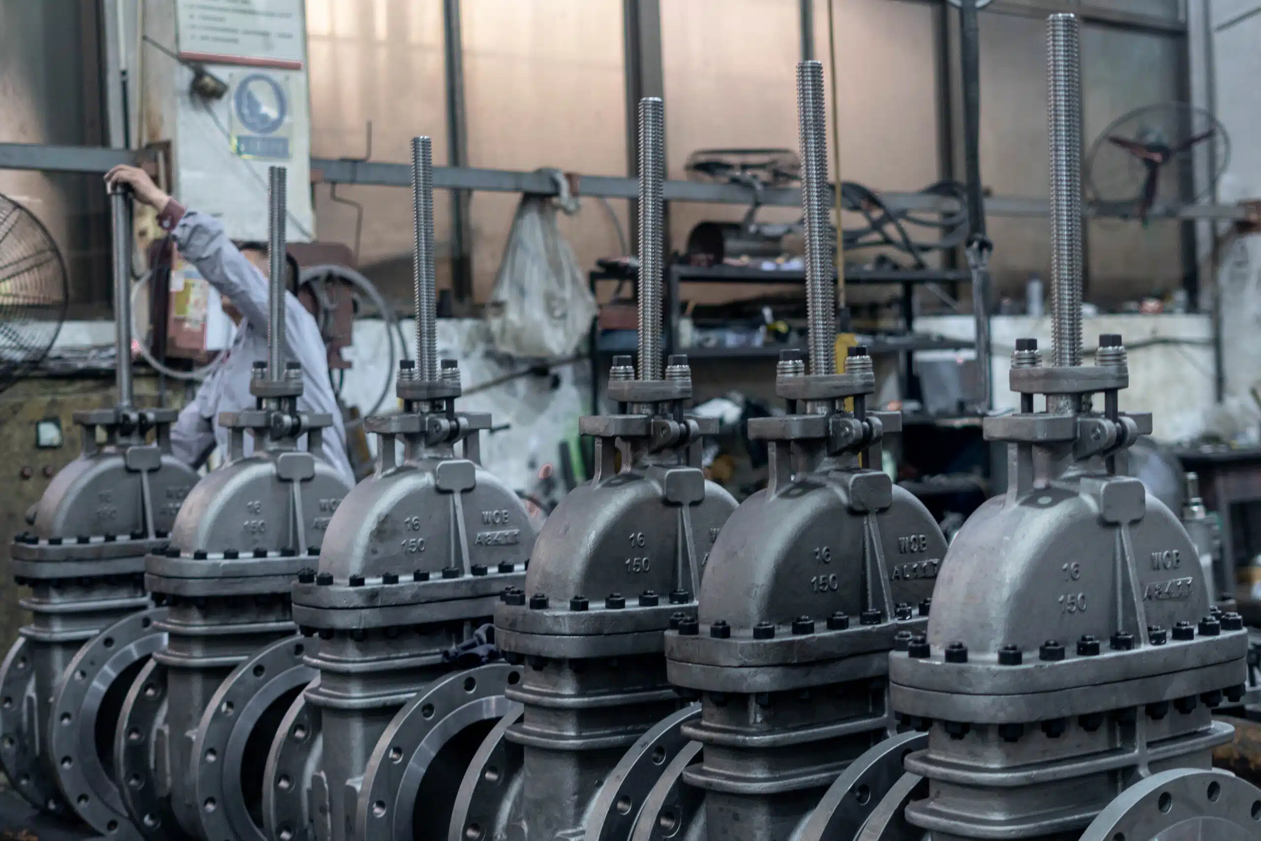 Real workshop photo of multiple rising stem flanged gate valves for industrial pipeline service.