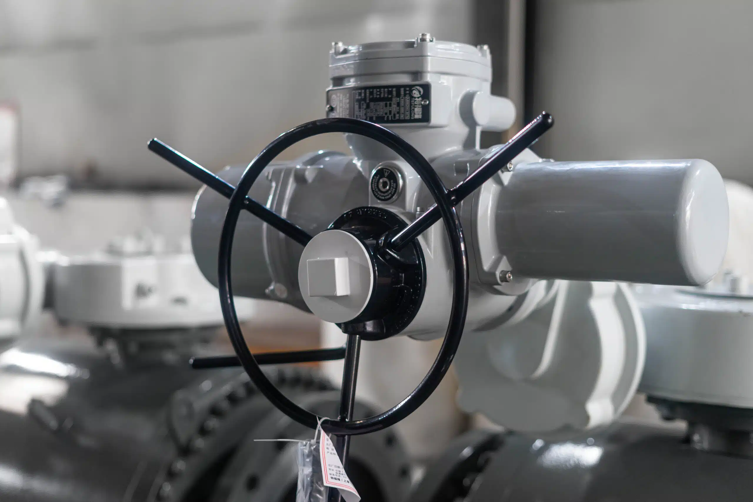 Close-up of a DN500 PN25 A105 three-piece trunnion ball valve with electric actuator and manual override handwheel.