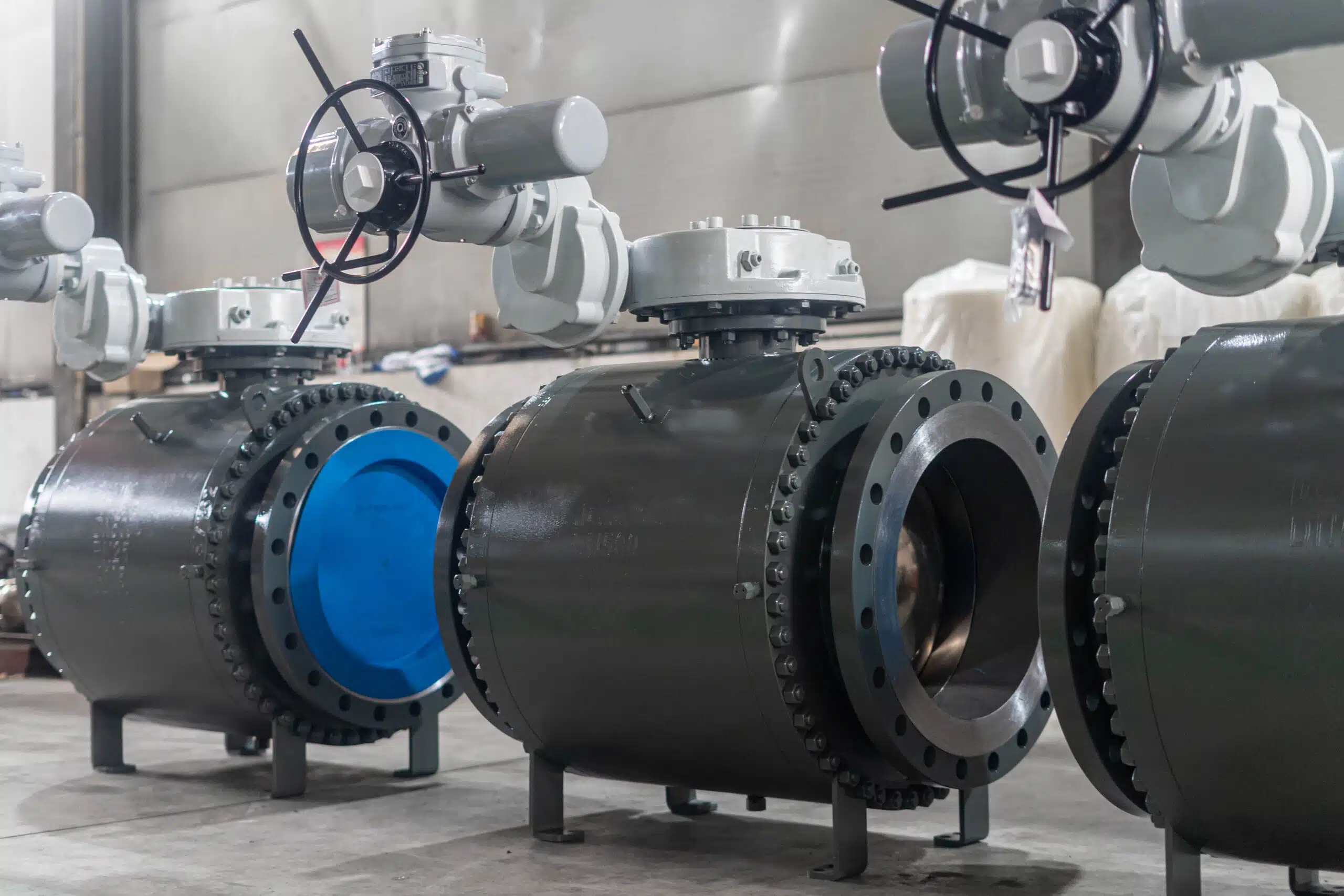DN500 PN25 A105 three-piece trunnion ball valves with electric actuators in an industrial workshop.